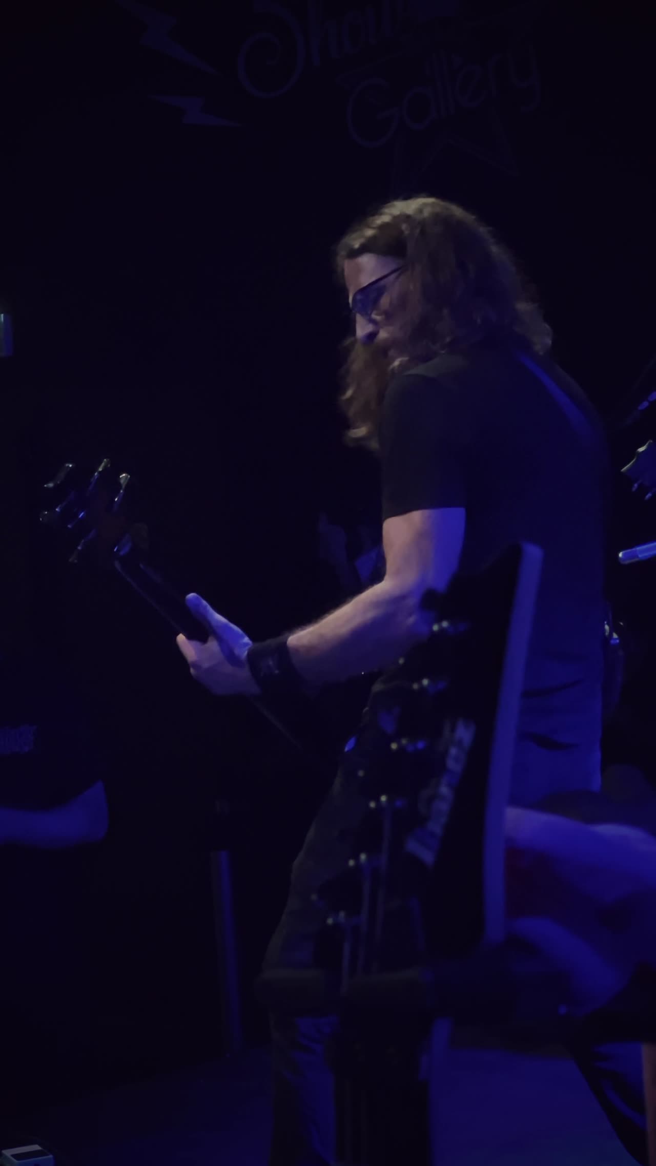 Un guitariste sur scène sous un éclairage bleu, image extraite du film de concert